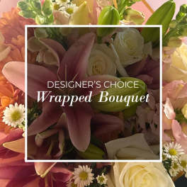 Wrapped bouquet of lilies, roses, and daisies in pink and white tones