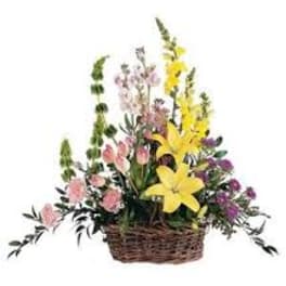 Basket arrangement with yellow lilies and pink flowers