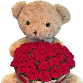 Teddy bear holding a basket of red roses with a ribbon