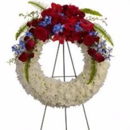 Standing funeral wreath with red roses and white flowers on an easel