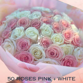 Bouquet of pink and white roses wrapped in pale pink paper