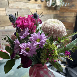 Pink and lavender mixed bouquet in a pink vase with ribbon