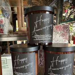 Three anniversary candles in dark glass jars with black lids