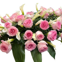 Pink roses and white calla lilies arranged in a low bouquet
