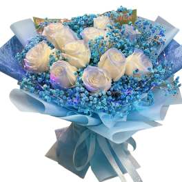 Bouquet of white roses with blue baby's breath and blue wrapping paper