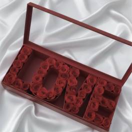 Red roses arranged in a gift box spelling "LOVE"