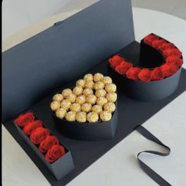 Heart-shaped gift box with red roses and gold-wrapped chocolates