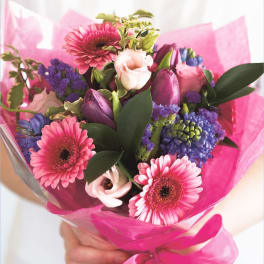 Pink and purple mixed bouquet wrapped in bright pink paper
