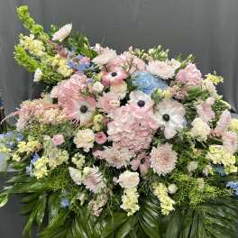 Large pastel floral arrangement with pink, white, blue, and yellow blooms