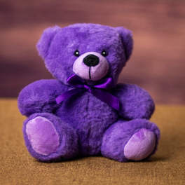 Purple teddy bear with a satin ribbon