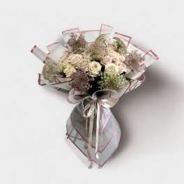 Bouquet of pale roses wrapped in translucent pink-edged paper