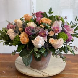 Mixed bouquet of roses and orchids in a ceramic vase