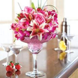 Pink and white floral arrangement in a tall glass goblet