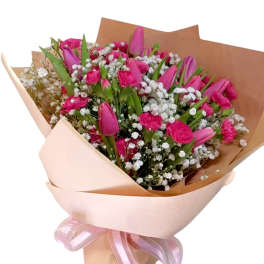 Pink tulip and carnation bouquet wrapped in peach paper