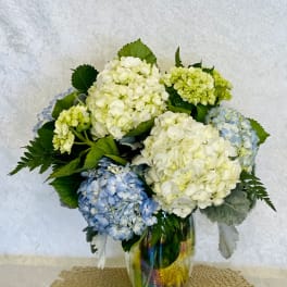 Blue and white hydrangea bouquet in a glass vase