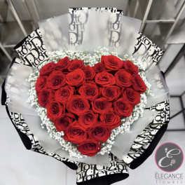 Heart-shaped bouquet of red roses with white baby's breath and black-and-white wrap