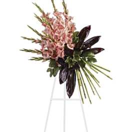 Pink floral spray on a white easel stand