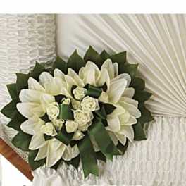 White floral bouquet with green ribbon accents on a white chair
