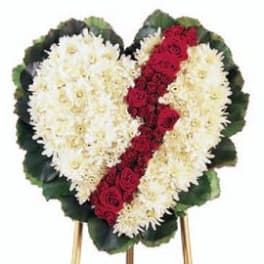 Heart-shaped funeral wreath with white flowers and a red rose diagonal