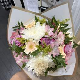 Bouquet of pink and white flowers wrapped in white paper