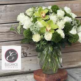 White rose bouquet with green orchids in a glass vase