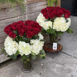 Two red rose and white hydrangea arrangements in glass vases