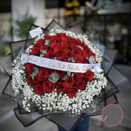 Large bouquet of red roses with white baby's breath and a ribbon banner