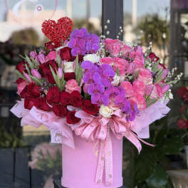 Large pink hat box of red and pink roses with purple orchids and a red heart pick