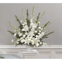 White floral arrangement in a clear pedestal vase
