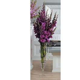 Tall purple floral arrangement in a clear glass vase