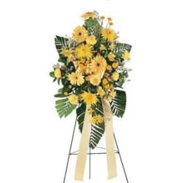 Yellow floral standing spray on an easel with ribbon