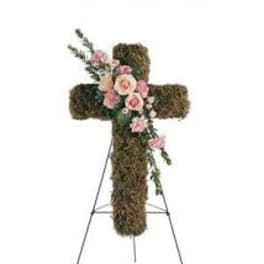 Floral cross on an easel with pink roses and greenery