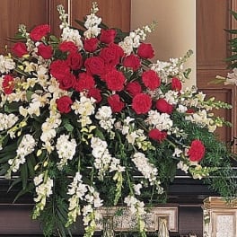 Large funeral spray of red roses and white flowers