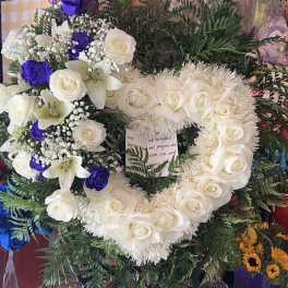 Heart-shaped floral wreath with white roses, lilies, and purple roses