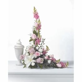 Pink and white floral spray beside a white urn