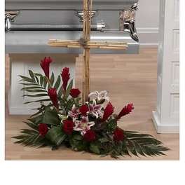 Red and white floral spray arranged around a bamboo cross