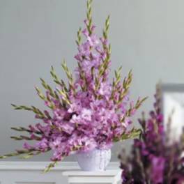 Tall purple floral arrangement in a white vase