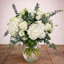 White hydrangea and rose bouquet in a clear glass vase
