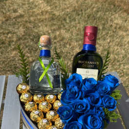Heart-shaped gift box with blue roses, chocolates, and two liquor bottles