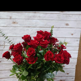 Red roses arranged in a clear glass vase