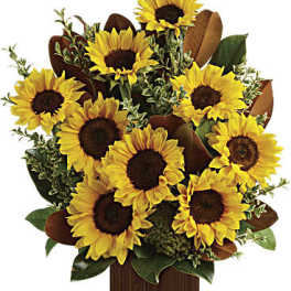 Sunflower bouquet in a wooden box with green foliage
