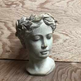 Stone-colored decorative bust of a woman with closed eyes