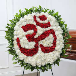 Large red and white floral funeral wreath on a stand