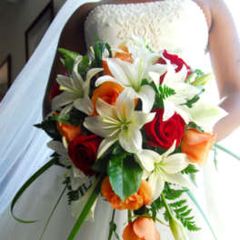 Bride holding a bouquet of white lilies, red and orange roses