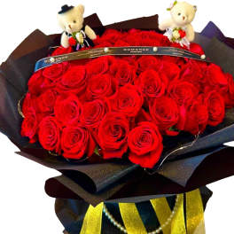 Bouquet of red roses with two teddy bears on top