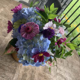 Bouquet of blue hydrangeas and purple daisies with greenery