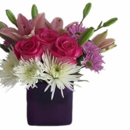 Pink roses and white lilies with daisies in a purple vase