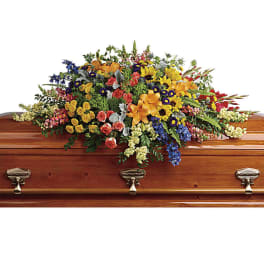Colorful floral spray arranged on a wooden casket