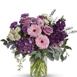 Bouquet of pink and purple flowers in a clear glass vase