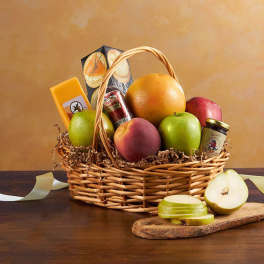 Fruit basket with apples, pears, citrus, and packaged snacks in a wicker basket